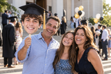 Family celebrating graduation with a custom Big Head cutout